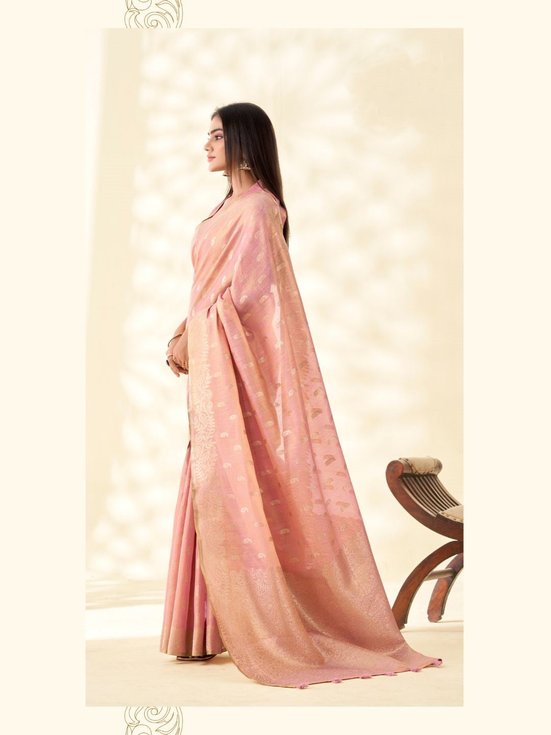 Model posing in baby pink tissue linen silk saree with zari butti and pallu showing full length elegant styling
