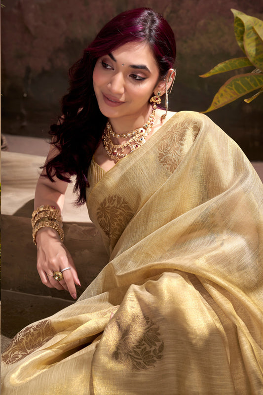 Close view of beige tissue silk saree showcasing zari weaving butta and elegant border detailing