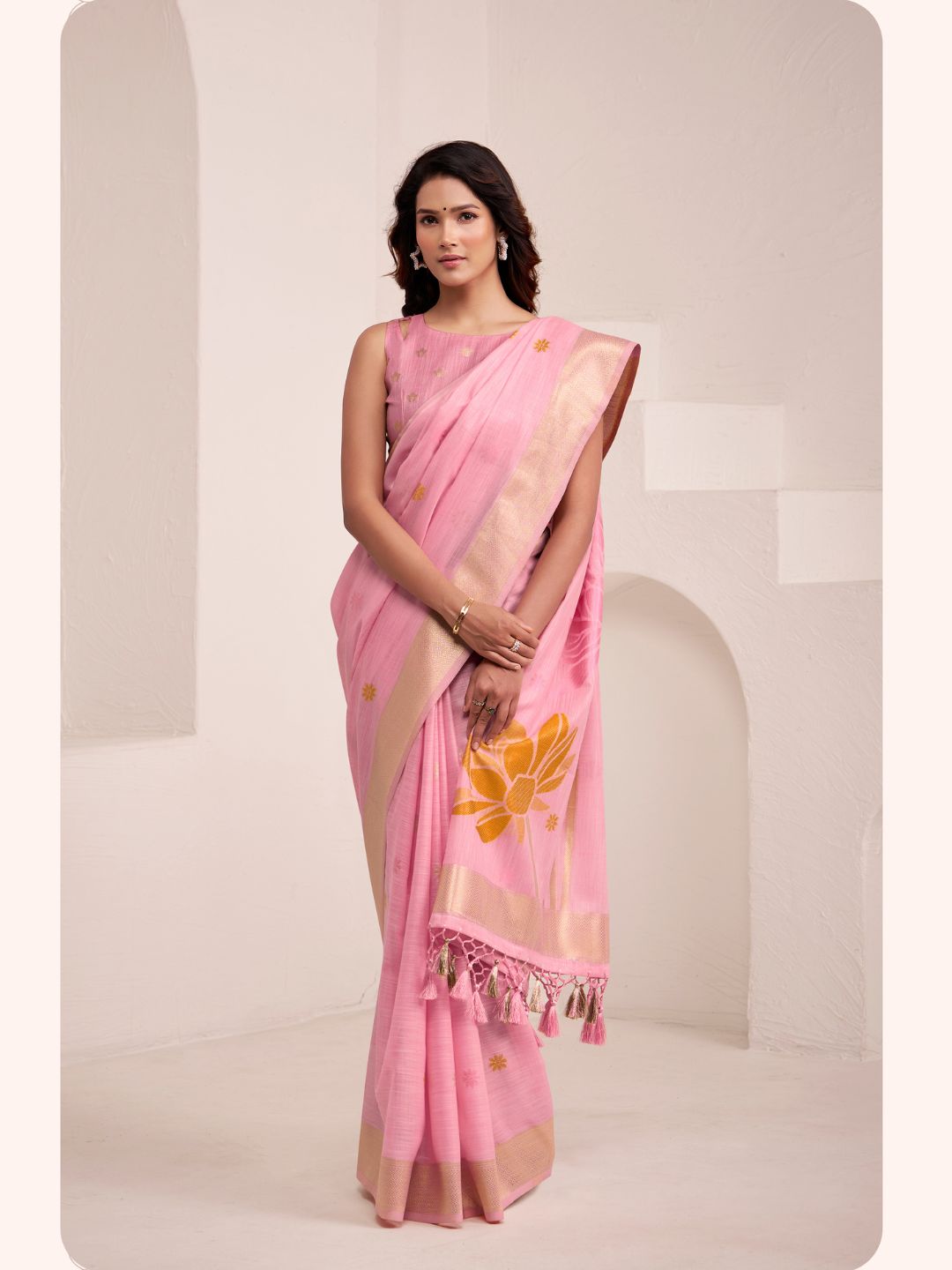 Model posing in pink soft linen silk saree with floral pallu showing full length elegant styling