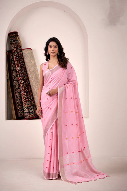 Woman wearing baby pink soft linen silk saree with zari weaving and elegant pallu full view