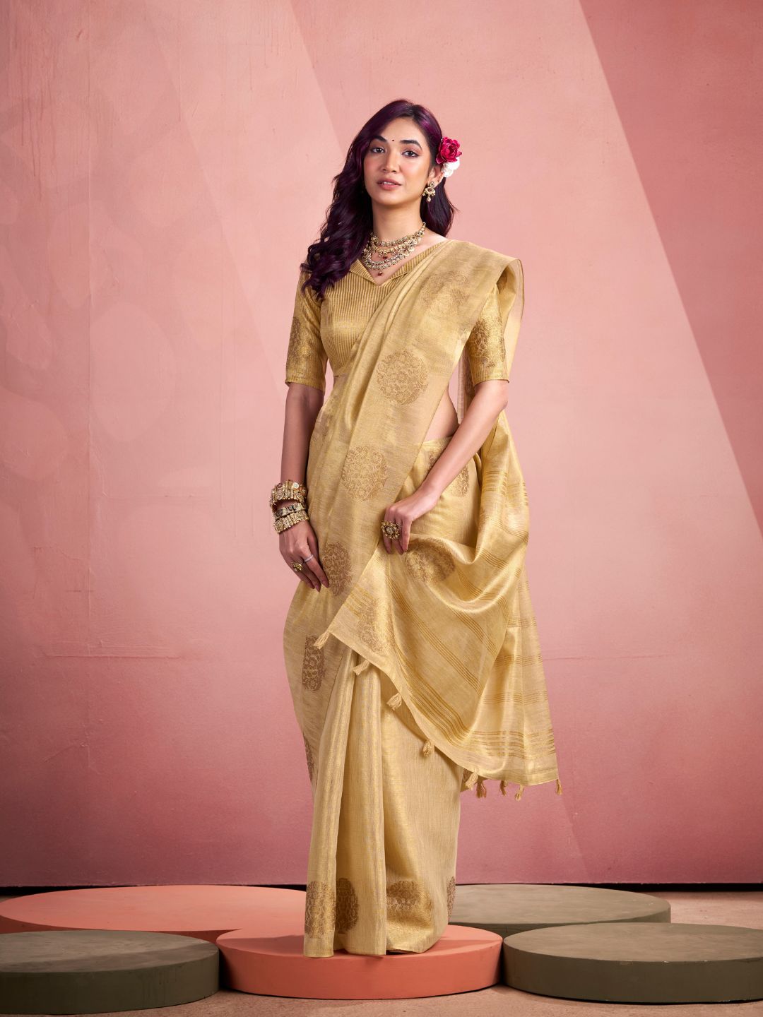 Model posing in beige tissue silk saree with zari butta showing full length party and wedding wear styling