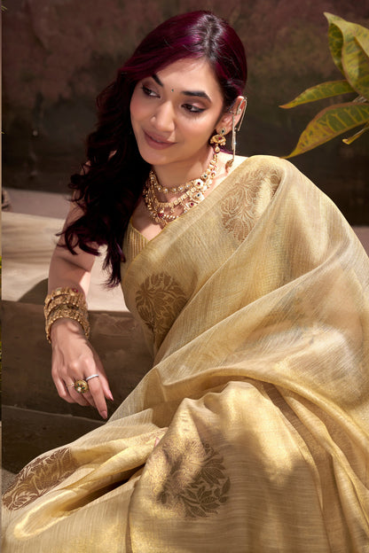 Close view of beige tissue silk saree showcasing zari weaving butta and elegant border detailing