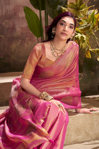 Model sitting in dark pink tissue silk saree with zari weaving butta highlighting graceful drape and rich texture