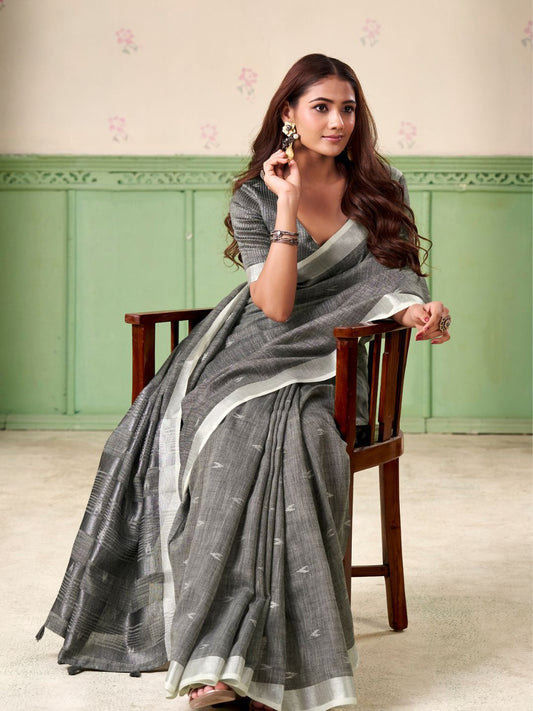 Model sitting in gray linen silk saree with woven butti design showcasing elegant office and party wear styling