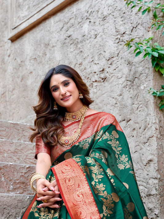 Model sitting in green Banarasi silk saree with Warli weaving and rich zari border showcasing elegant styling