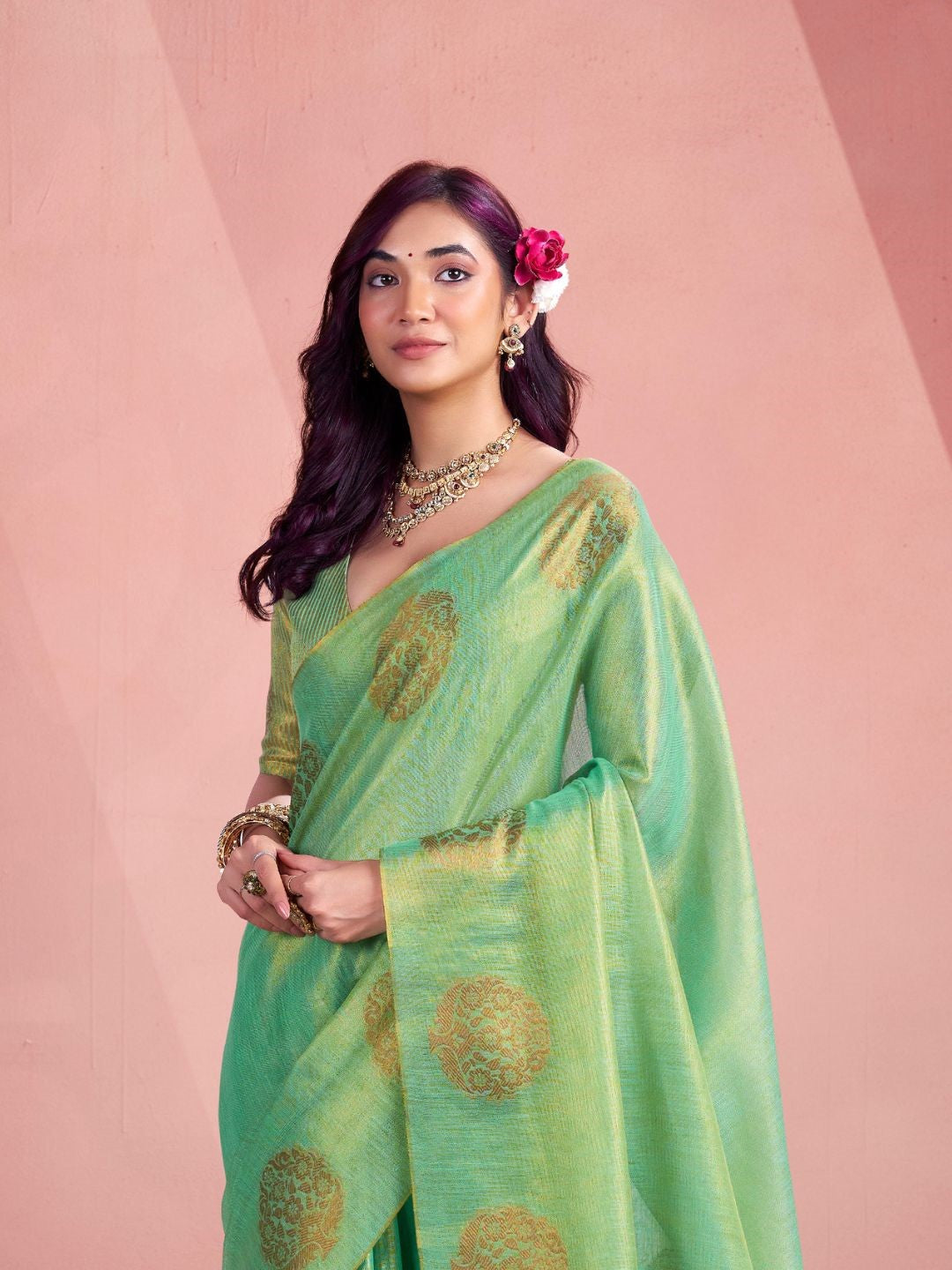 Close portrait of green tissue silk saree with fancy zari weaving butta highlighting rich texture and drape