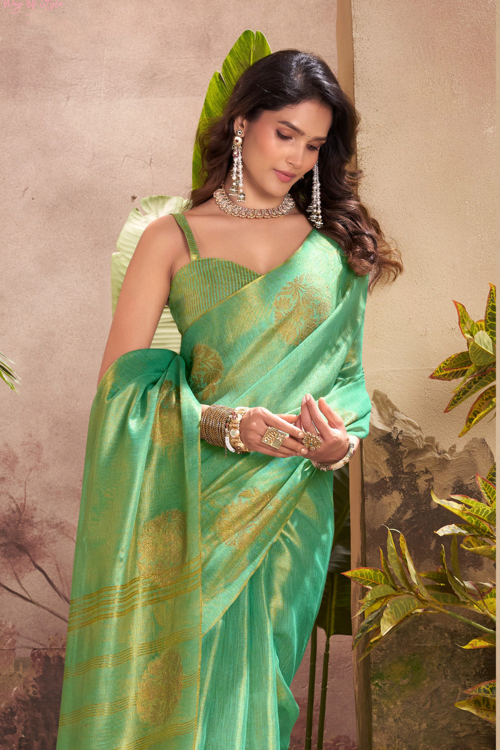 Close portrait of green tissue silk saree with zari weaving butta highlighting rich texture and graceful drape