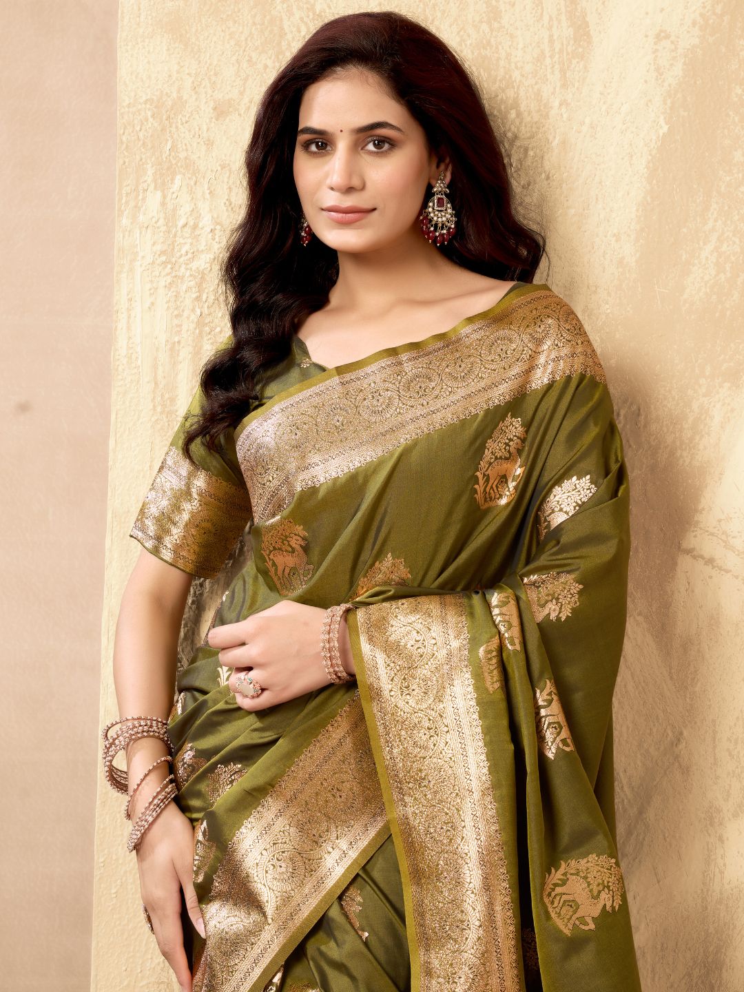 Portrait of model wearing mehndi green Banarasi silk saree with zhallar border highlighting elegant drape