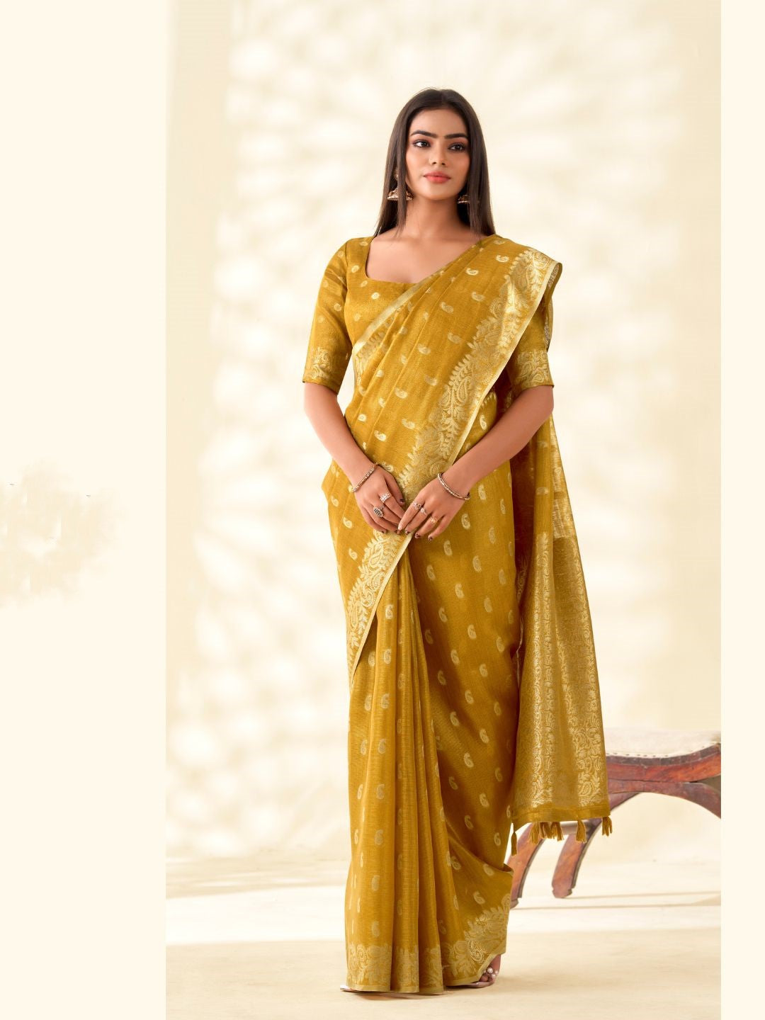 Model posing in mustard yellow tissue linen silk saree with zari butti and pallu showing full length elegant styling