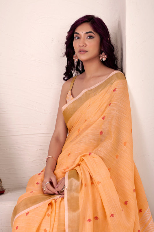 Close view of orange linen silk saree with zari weaving showcasing elegant drape and fine detailing