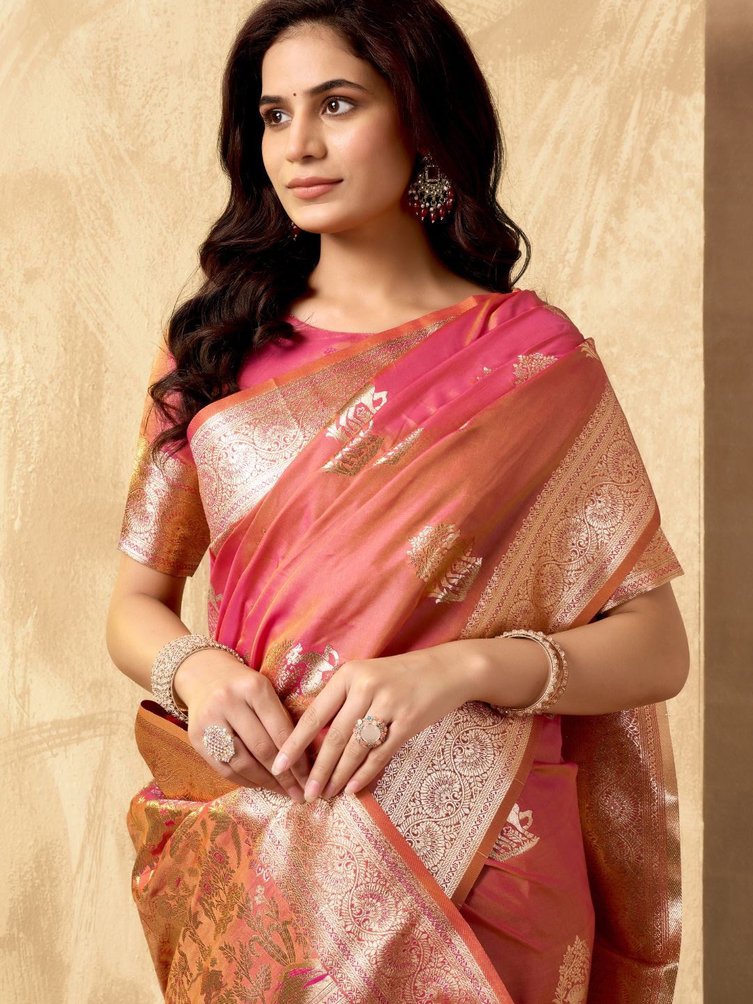 Portrait of model wearing peach Banarasi silk saree with zhallar border highlighting elegant drape