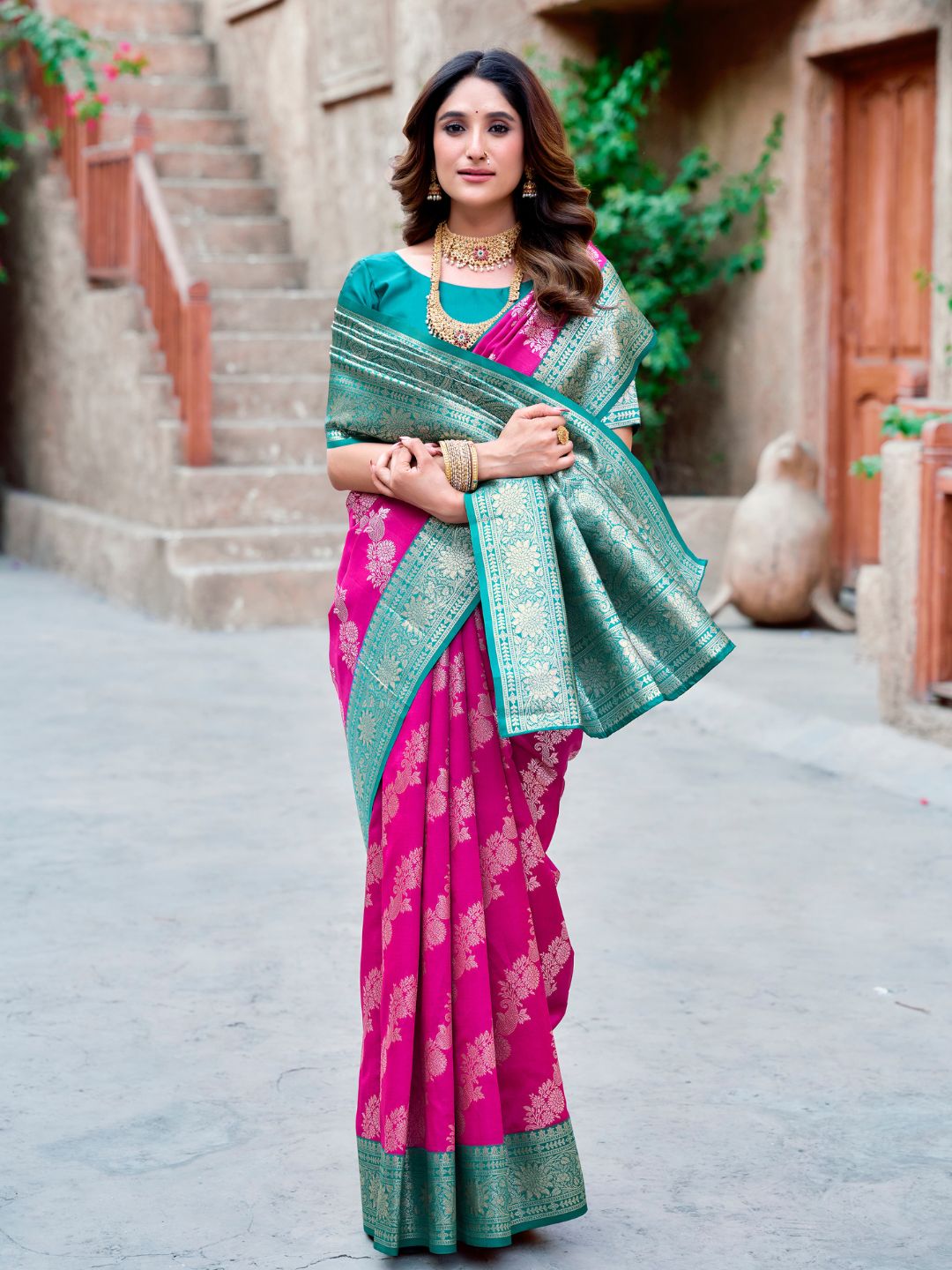Model posing in pink Banarasi silk saree with Warli work showing full length wedding and festive styling