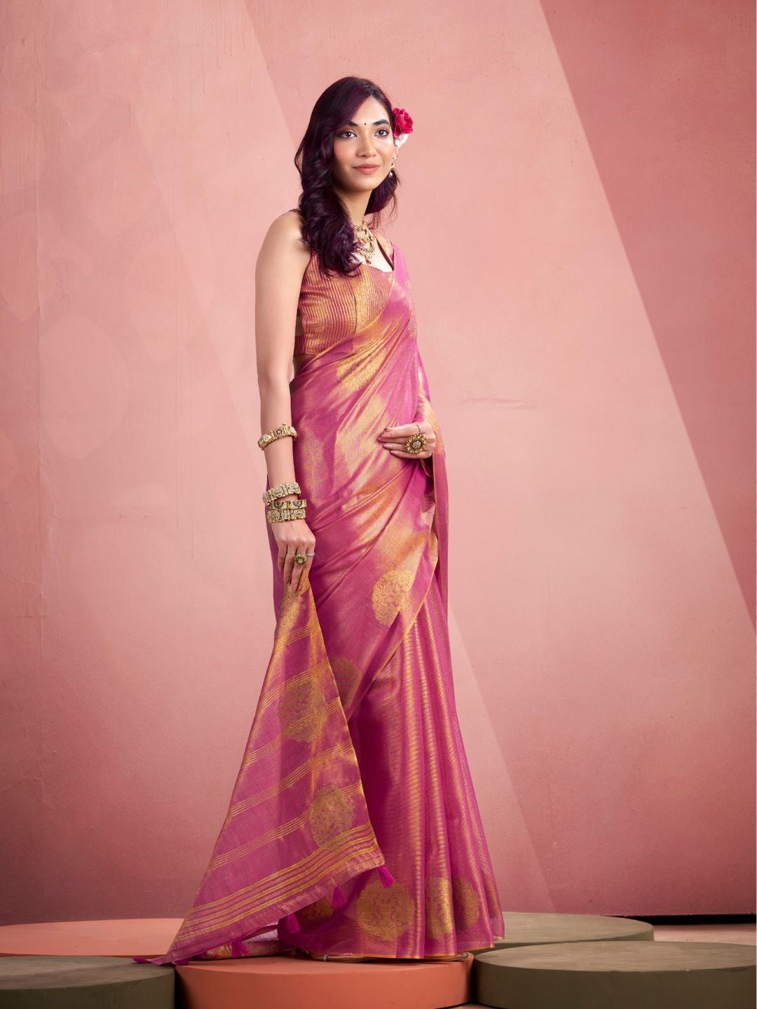 Model posing in pink tissue silk saree with zari butta showing full length party and wedding wear styling