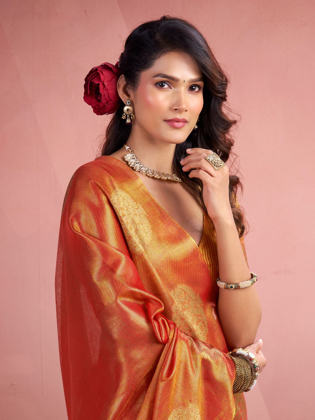 Close view of red tissue silk saree with fancy zari butta showcasing rich fabric and detailing