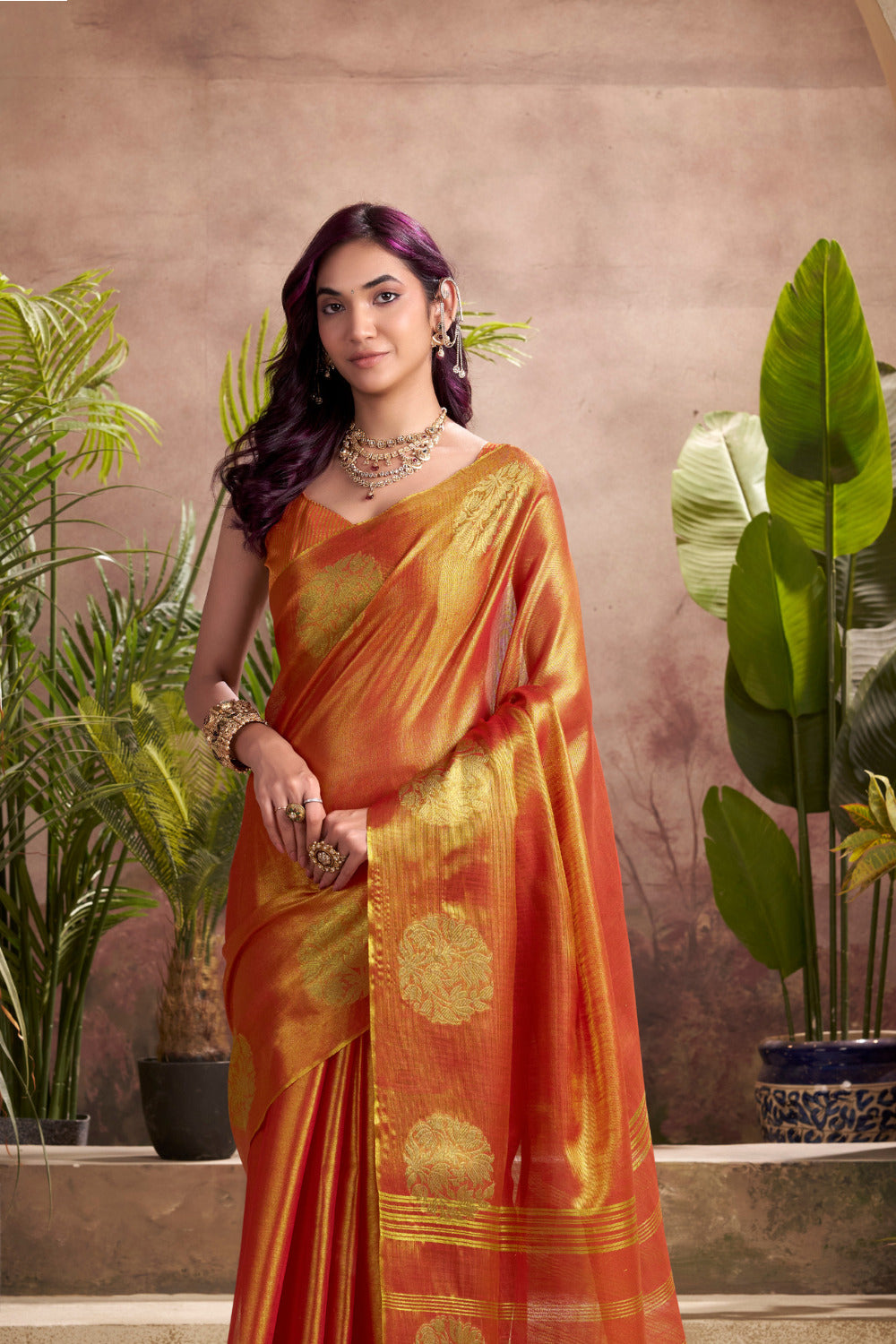 Close view of red tissue silk saree showcasing zari weaving butta and elegant border detailing