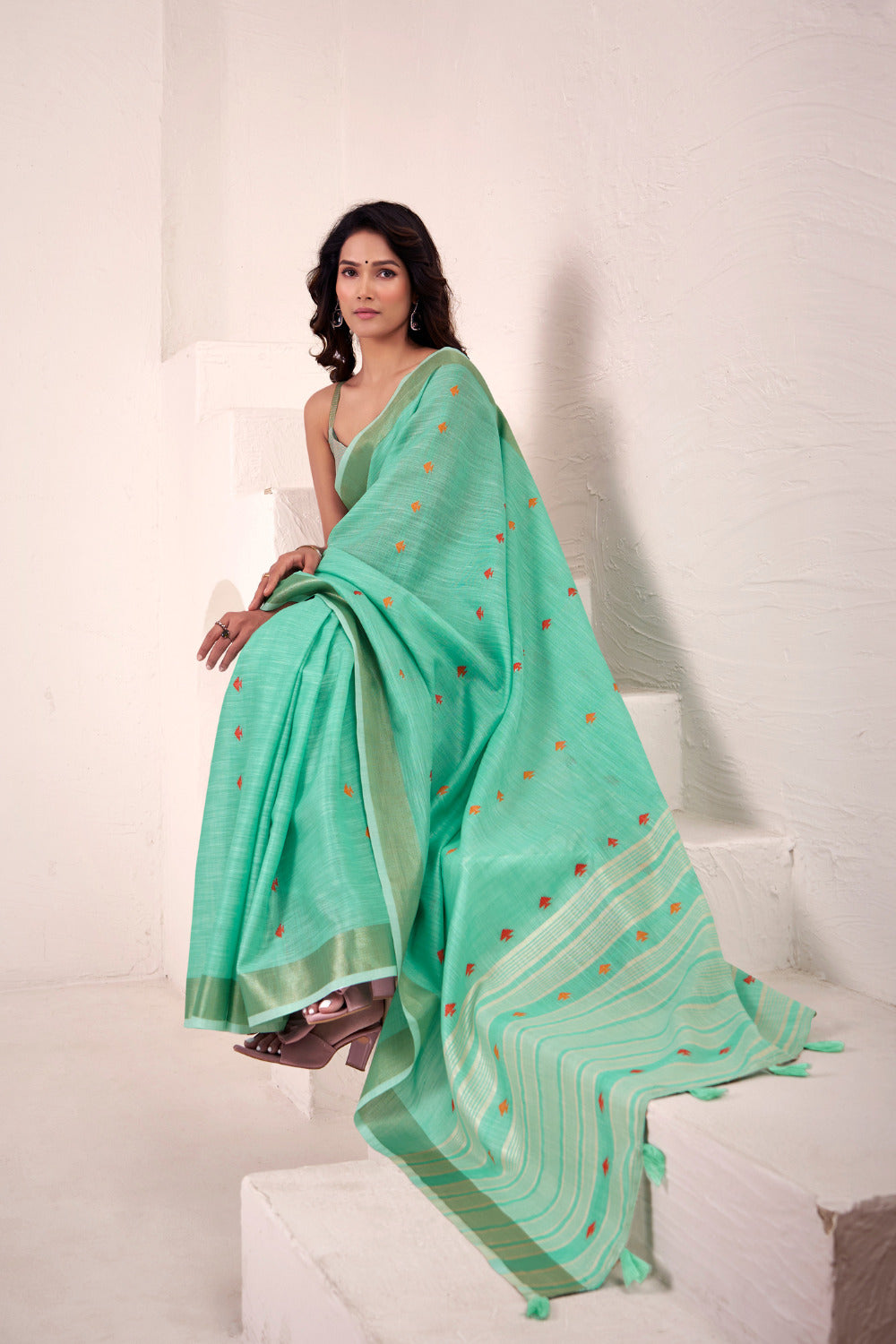 Sea green linen silk saree with zari weaving showcasing side pose and graceful flowing drape