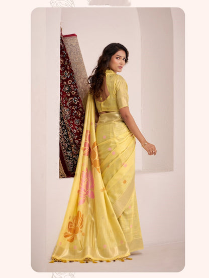 Woman walking in yellow soft linen silk saree with floral pallu highlighting flowing drape