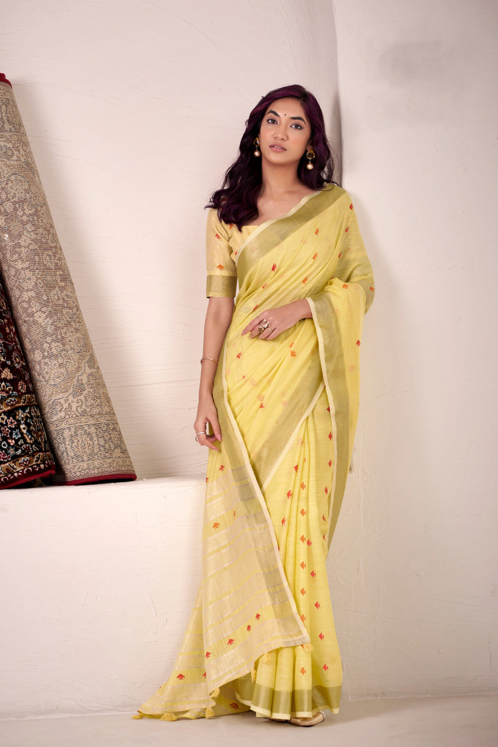 Model posing in yellow linen silk saree with zari work showing full length ethnic styling