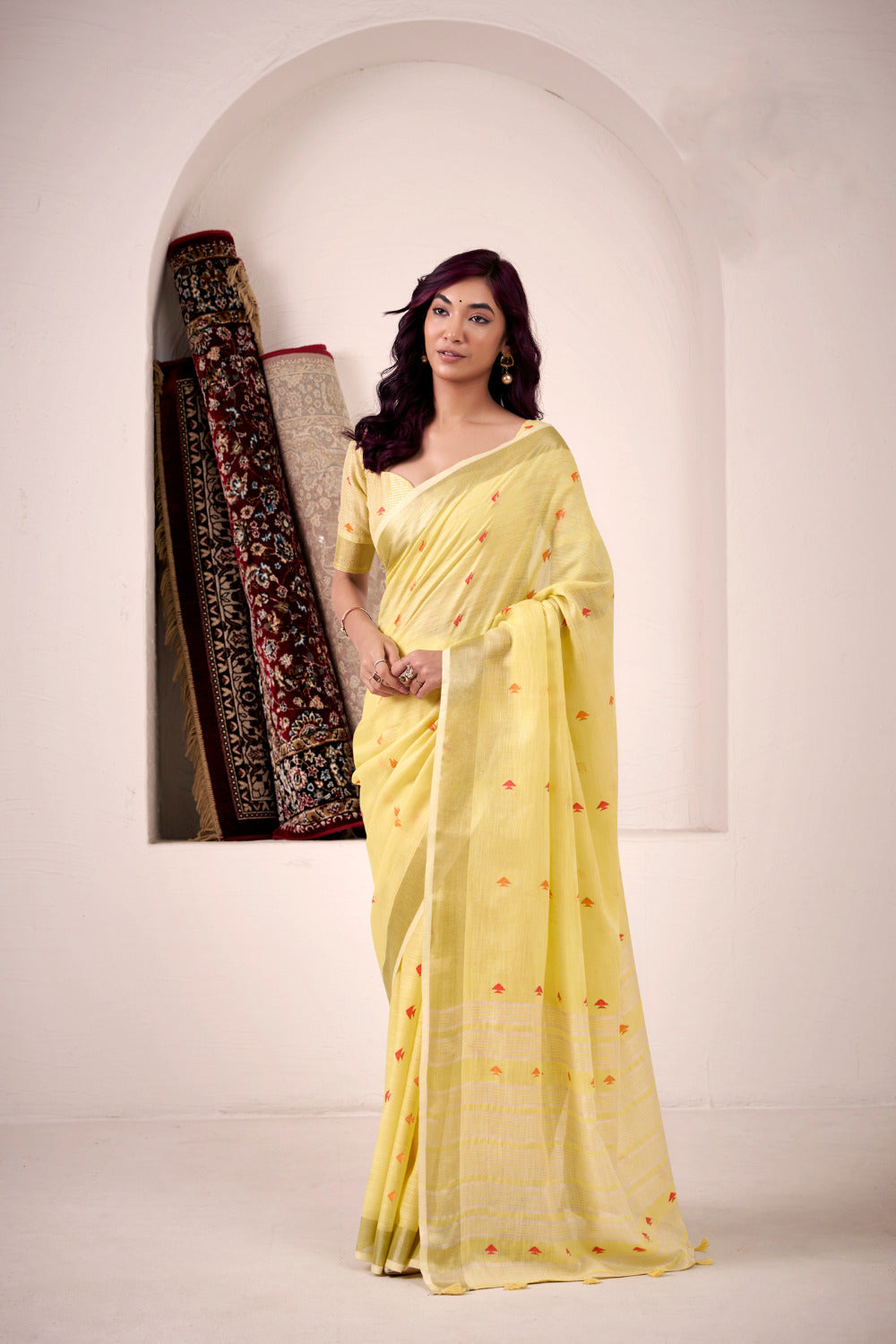 Woman wearing yellow soft linen silk saree with zari weaving and elegant lining pallu full view